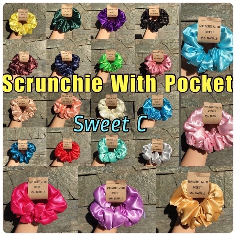 A display of various colored silk scrunchies with attached pockets and zippers, labeled "silk Scrunchies With Pocket Zipper" and "Sweet C," arranged on a flat surface.
