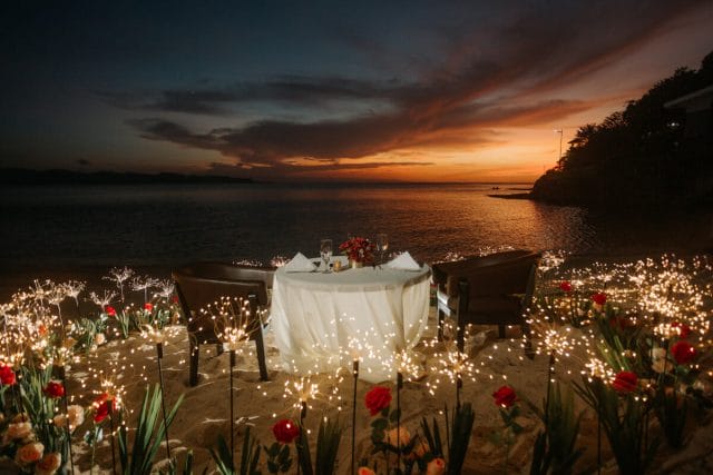romantic dinner setup by the beach with sunset behind, honeymoon places in the philippines