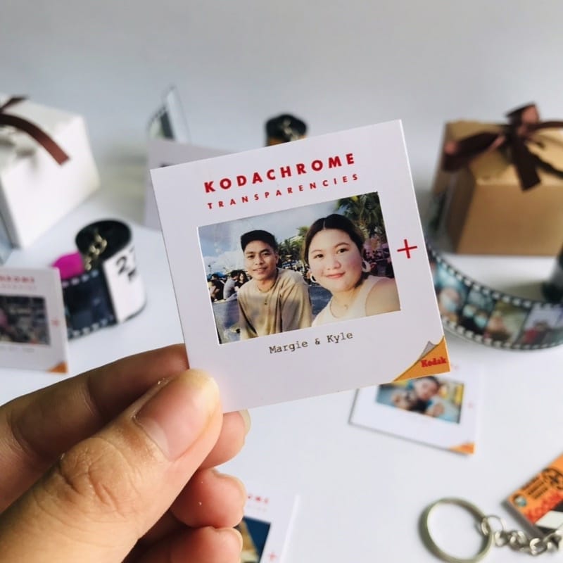 A person is holding a keychain with a photo of Mini Kodachrome Film Slide.