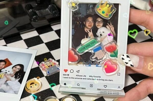 A person holding an Ohaya Emoji Shaking Happy Photo Frame with stickers on it.