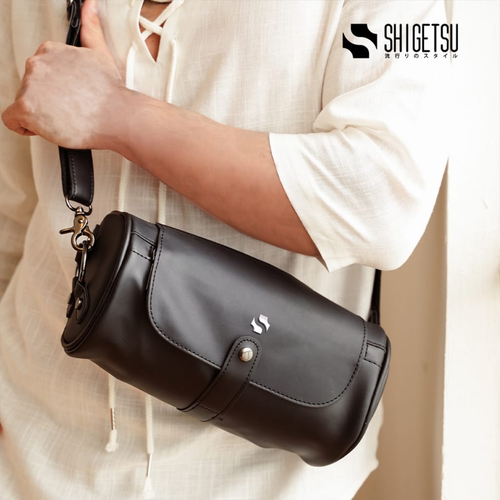 A man is holding a Shigetsu ESASHI Leather Sling Bag for Men.