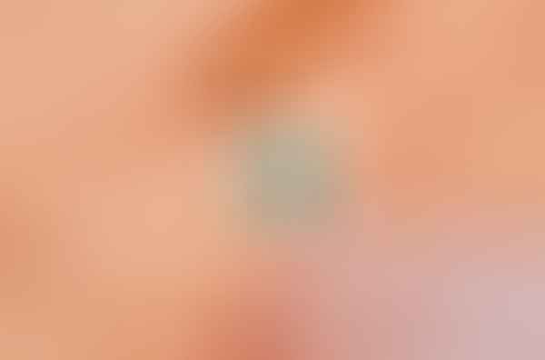 A woman's hand is holding a Tala by Kyla My Universe Fidget Ring with a blue stone.