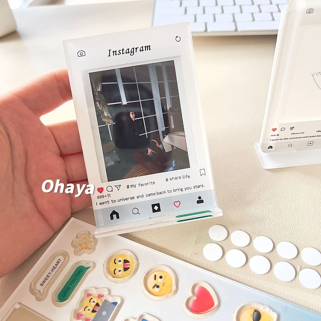 A person is holding an Ohaya Emoji Shaking Happy Photo Frame on a desk.
