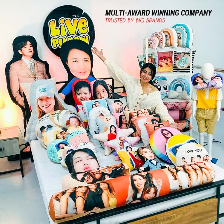 A group of people posing in front of a LIVEPILLOW Custom Human Bolster Pillow bed.