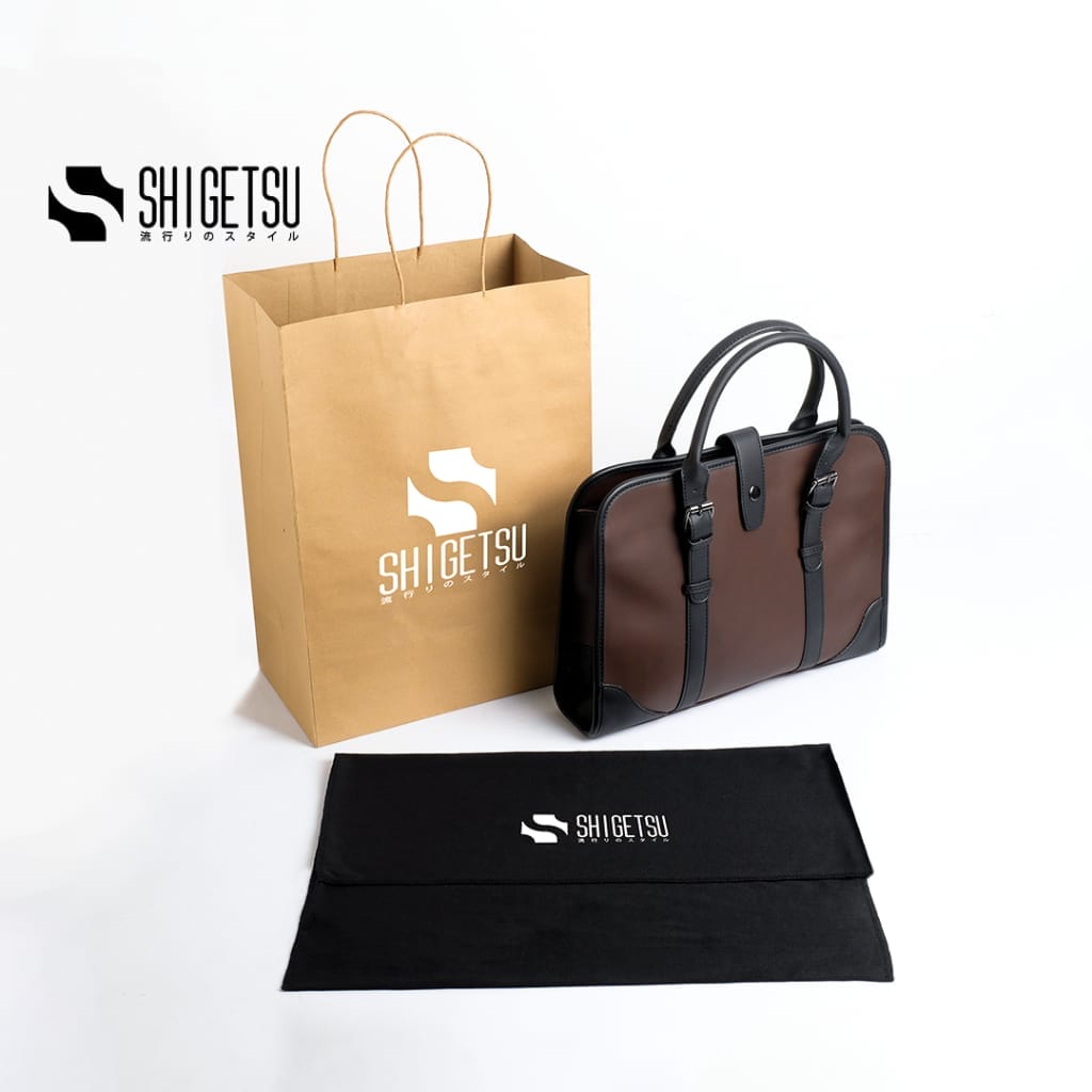 A black and brown Shigetsu ESASHI Leather Sling Bag for Men with a brown paper bag.