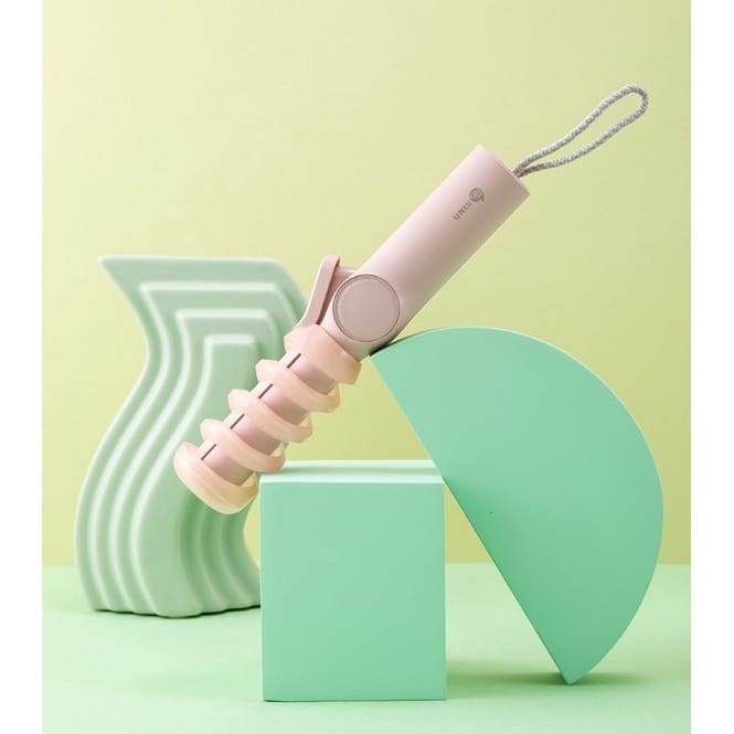 A pink toothbrush with a pink handle on a green background is part of the UNIX Mini Wireless Iron Collection.