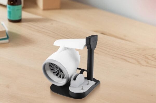 A compact Turbo Jet Fan and Humidifier Engine, featuring a white body on a black stand, is positioned on a wooden desk.